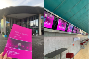 SDSS AGM Programme held in front of Perth Concert Hall and a row of plasma screens showing SDSS logo