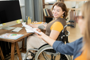 Woman in wheelchair being handed something.