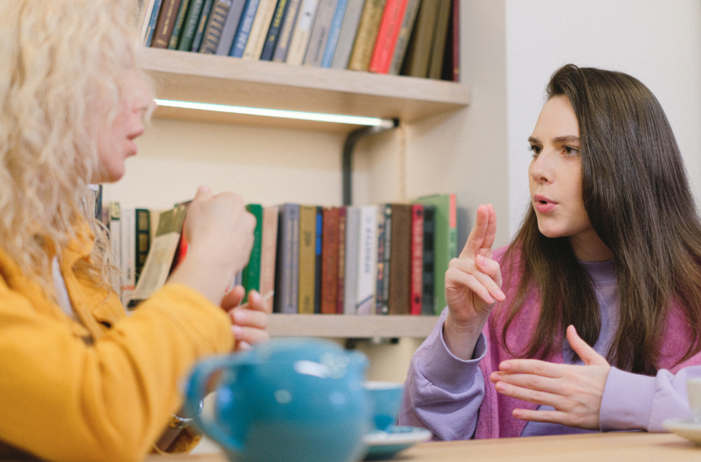 Two young women talk using sign language